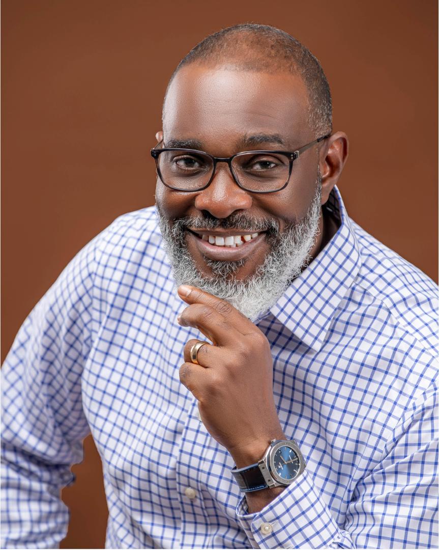 Smiling man with a grey beard in a blue check shirt