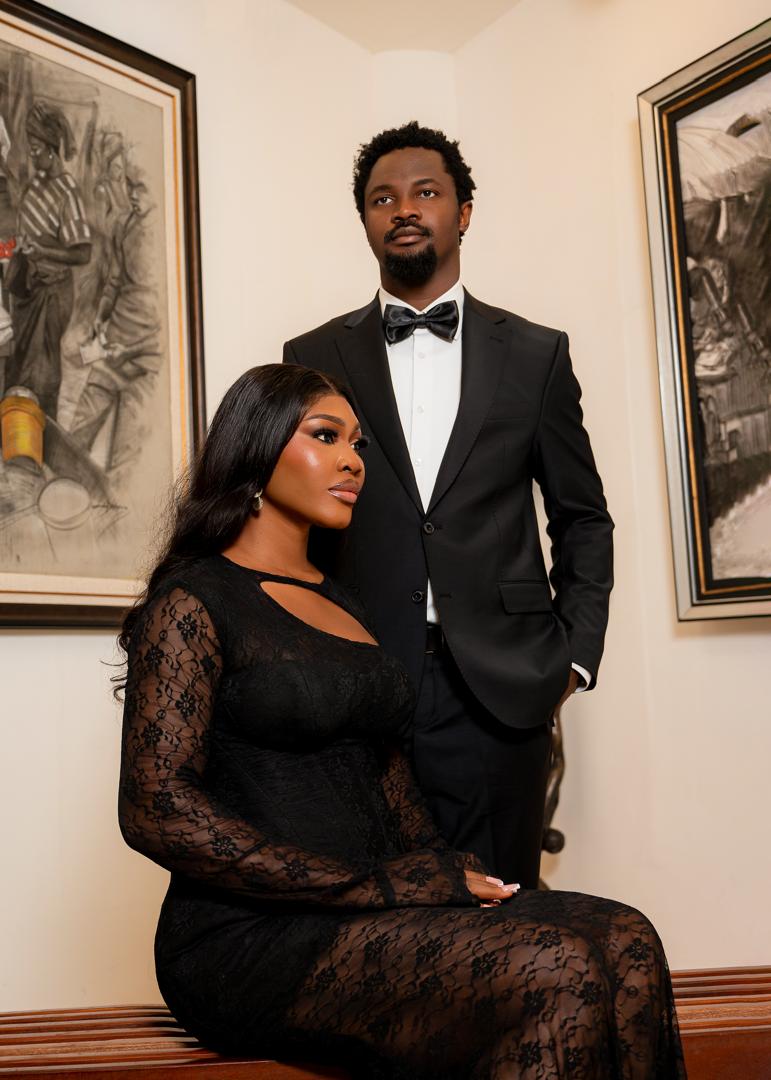 Couple in black tie and lace beside framed artwork