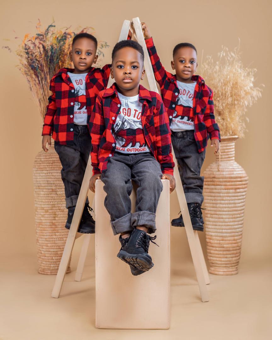 Triplets in red and black plaid on a studio ladder