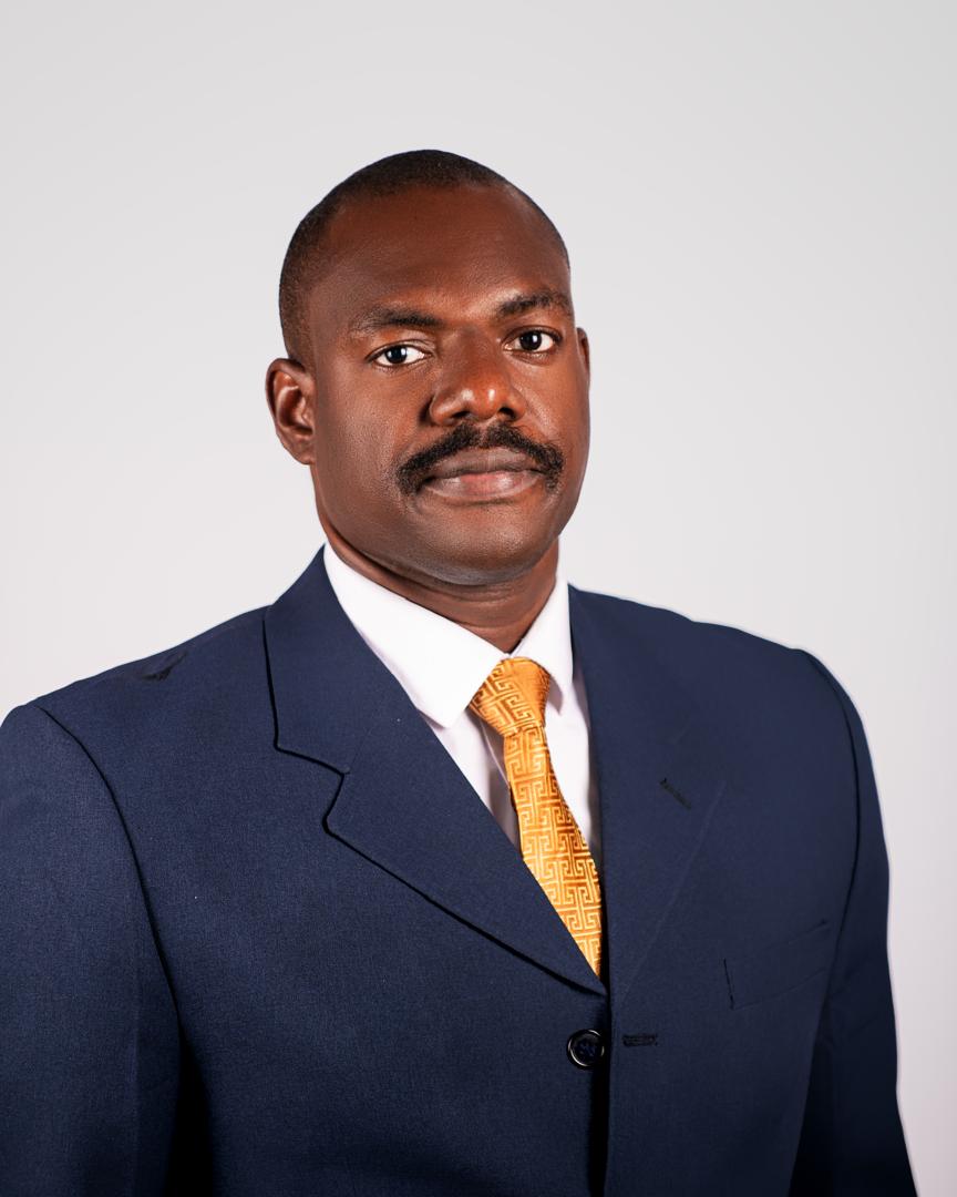 Corporate headshot in a navy suit and gold tie