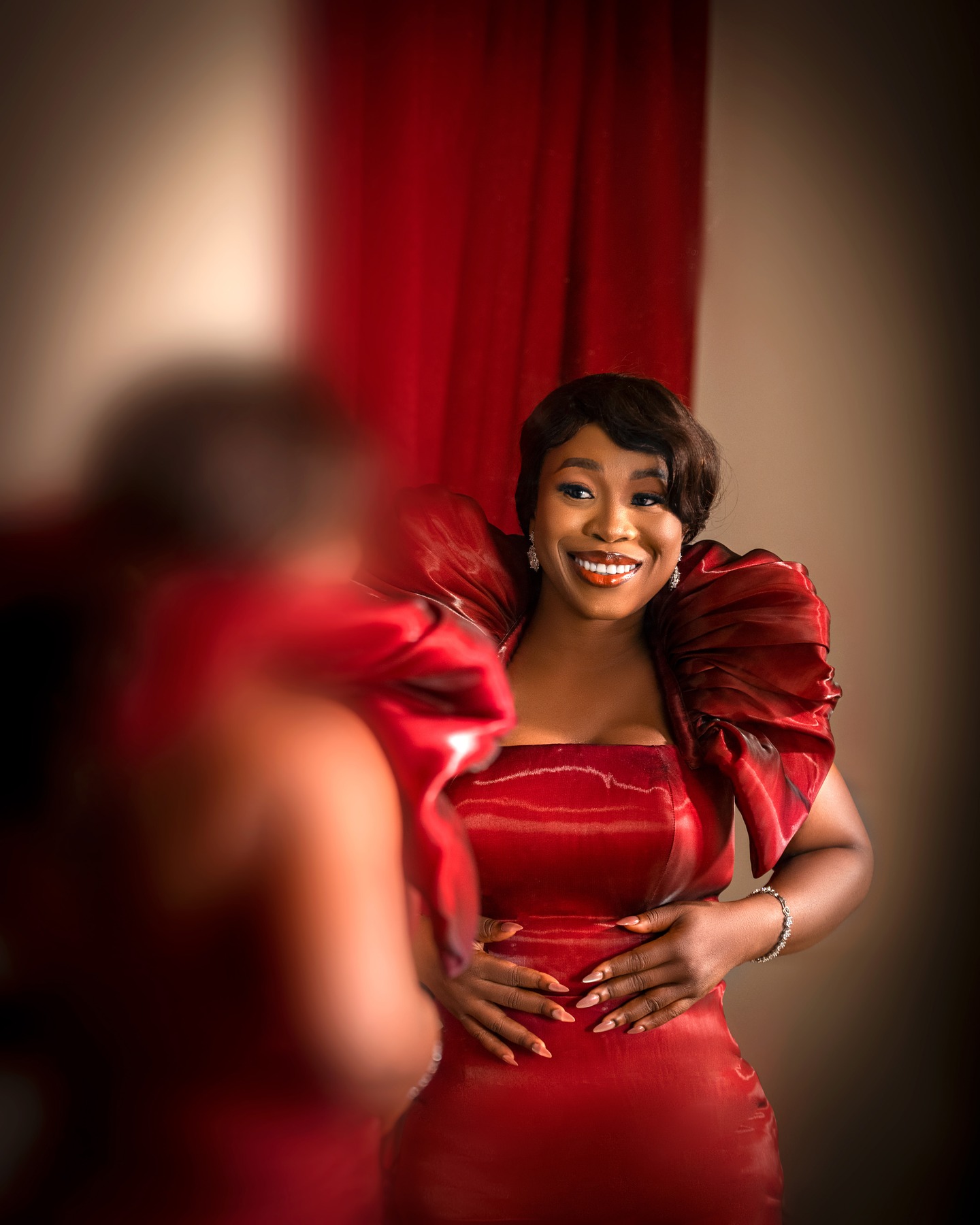 Woman in a red gown reflected in a mirror