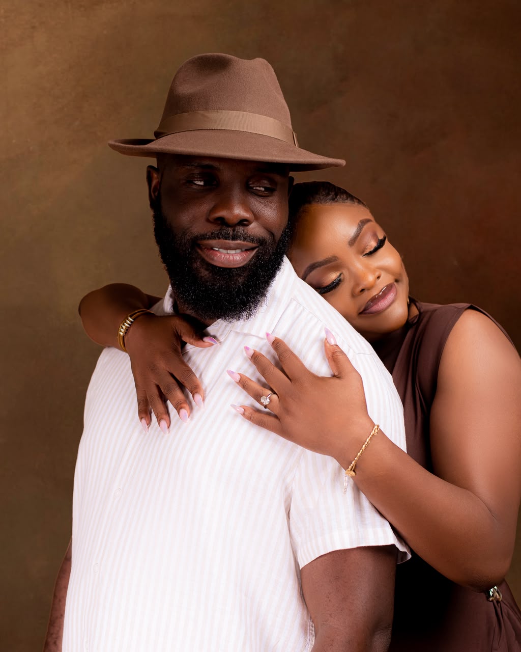 Woman embracing a man in a brown fedora