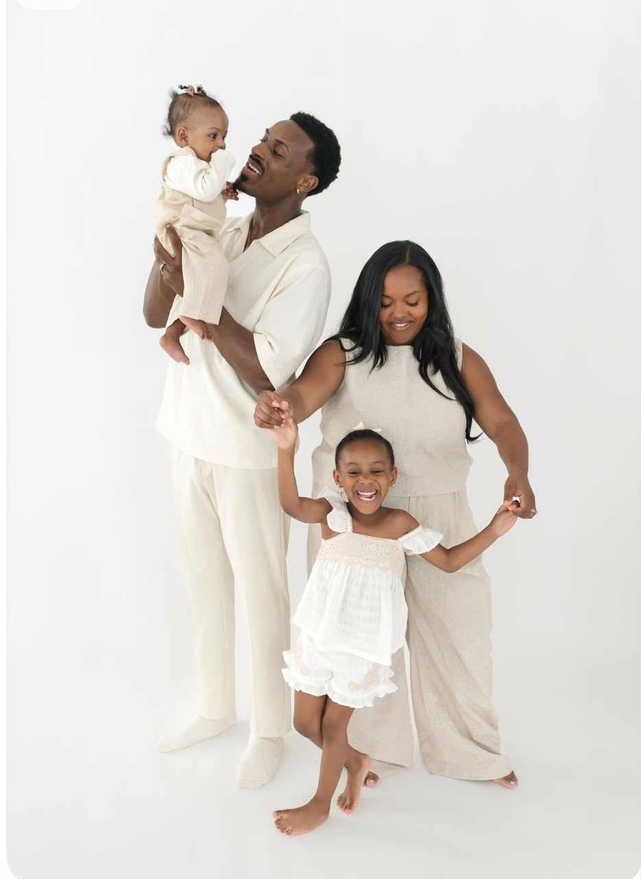 Young family in cream tones playing together in the studio