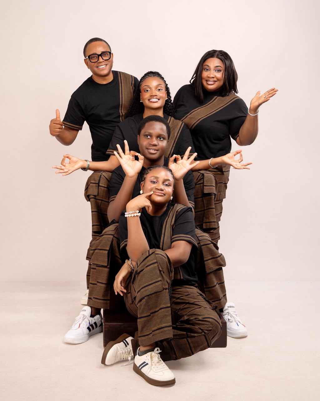 Family of five posed together in black and brown outfits